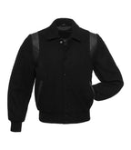 Front view of an all-black wool varsity jacket featuring a shirt-style collar, black leather shoulder inserts, and matching black ribbed cuffs and hem.