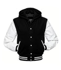 Front view of a black hooded varsity jacket with white leather sleeves, snap-button closure, and striped rib-knit waist and cuffs.